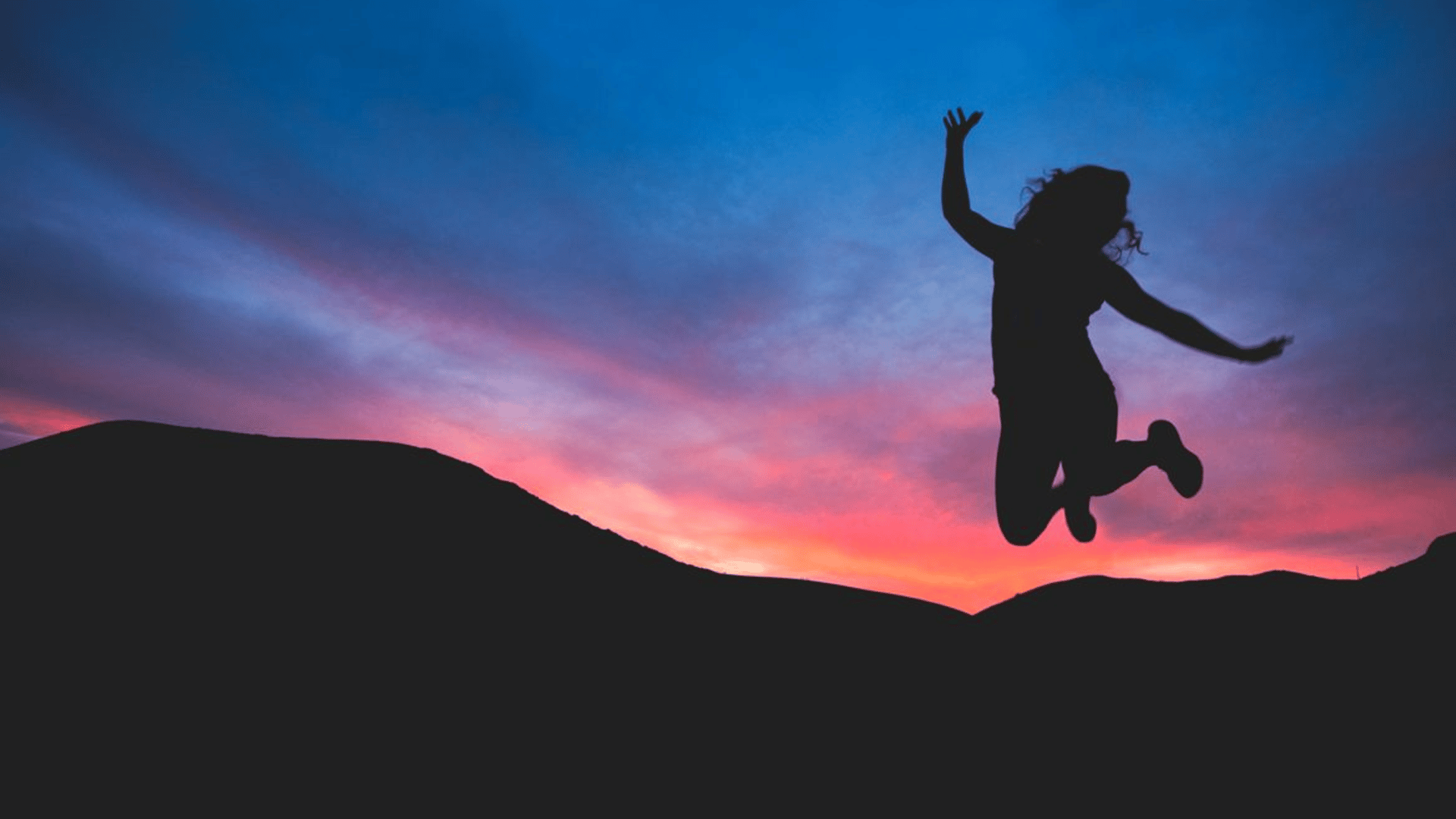 Person jumping in front of sunset