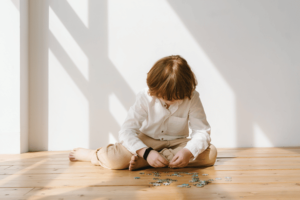 Child doing jigsaw puzzle sat on floor
